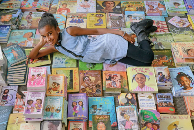 A girl laying amongst hundreds of books